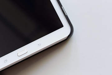 Dettaglio di un tablet su tavolo bianco
