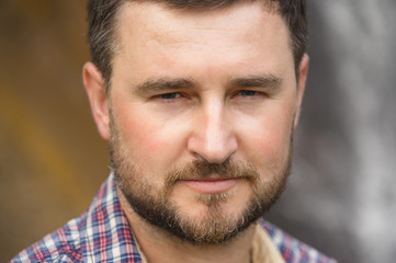 Obraz premium Close-up portrait of a bearded hipster against a waterfall background