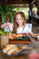 Little girl eating pizza
