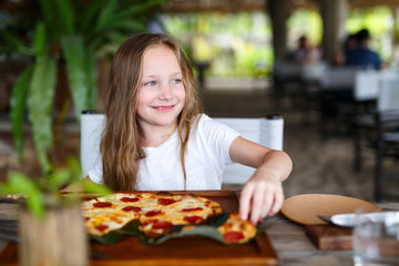 Little girl eating pizza