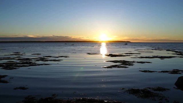 Blue and purple sunset in Rimouski, Quebec by Saint Lawrence river in Gaspesie region of Canada with closeup of water shore and waves
