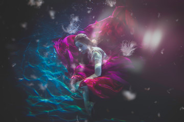 Fototapeta na wymiar Beautiful woman swimming with fancy dress underwater