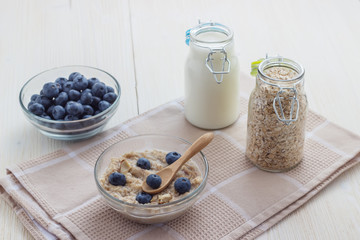 A simple healthy breakfast of oatmeal with blueberries and milk in a bottle