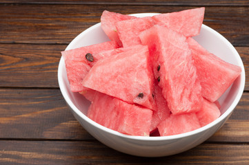 watermelon slices in plate on dark wooden background