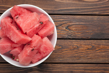 watermelon slices in plate on dark wooden background top view