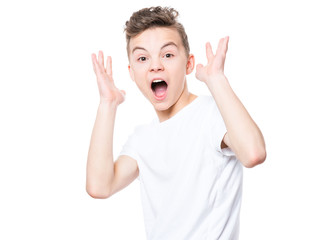 Emotional portrait of amazed or surprised teen boy in white t-shirt. Funny cute cheerful child screaming with wide open mouth, isolated on white background. 
