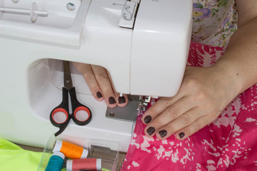 Naklejka premium processes of sewing on the sewing machine sew women's hands sewing machine. Female tailor threading leather material on sewing machine