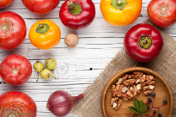 autumn vegetables on white wooden background sweet pepper, tomatoes top view, frame, copy space