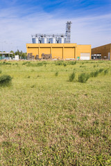 Fototapeta na wymiar External view of a typical factory Building with agricultural silos