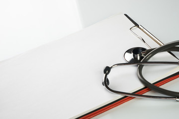 Stethoscope and clipboard with blank white sheet of paper