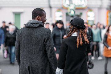 Stylish pedestrians on crowd background. African American couple. Unrecognizable young people on street, city life, youth love relationship