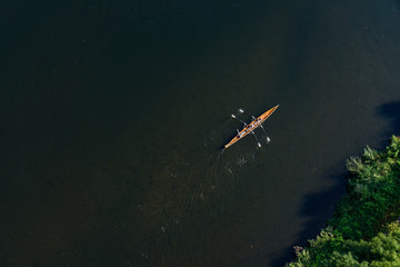 Luftbild - Drei Männer rudern auf dem Fluss mit einem zweier Ruderboot mit Steuermann