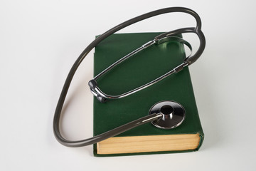 Concept of medical education with old green medical book and stethoscope