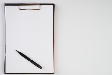 Clipboard with white sheet and black pen