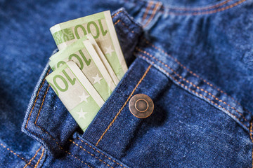 Money in the pocket. Close-up of one hundred Euro banknote in jeans pocket.