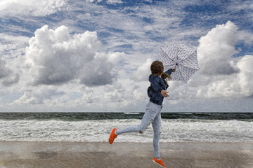 Frau mit Regenschirm an der See