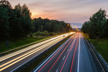 Speed traffic on highway at dusk. Colorful light trails on the street. Poland.