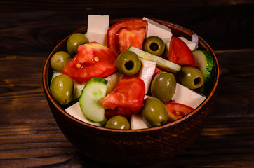 Greek salad in a bowl on wooden table