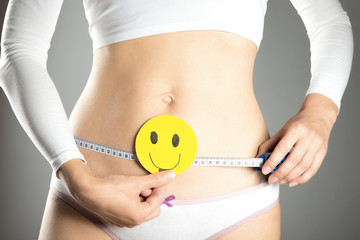 Conceptual picture of a beautiful female belly with smileys