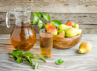 Pears in a wooden dish and a carafe of pear juice