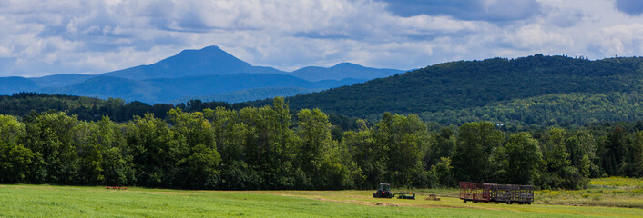 banner showing haying the fields  with view of Camels Hump Mountain , Green Mountains of Vermont


