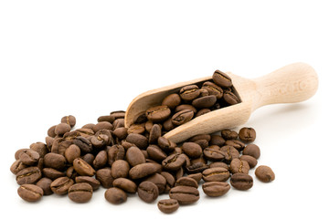 Coffee beans with a wooden shovel on white, isolated.