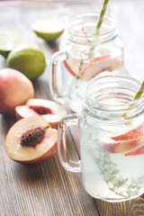 Glass jar of lime water with slices of peach