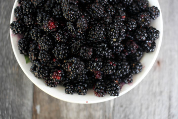 bowl of blackberries on wooden table