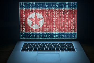 North Korea hacker. Laptop with binary computer code and Korean flag on the screen. Internet and...