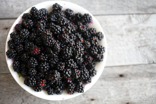 bowl of blackberries on wooden table