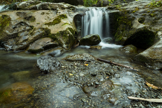 A waterfall cascading between moss covered rocks