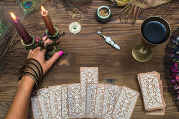 Fortune teller female hands and tarot cards on wooden table. Concept of divination.