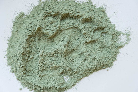 Green cosmetic clay powder. natural clay mask for face and body. Green cosmetic clay texture close up. a solution of cosmetic clay abstract background