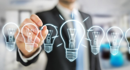 Businessman drawing a sketch lightbulb with a pen