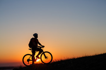 Fototapeta na wymiar Silhouette man stand with mountain bike on the meadow