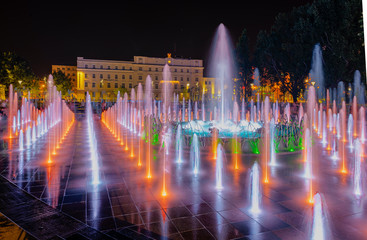 Night colorful fountain show inLublin park. Vivid color fountain water - obrazy, fototapety, plakaty