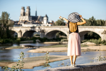 Fototapeta na wymiar Young woman tourist standing back on the beautiful cityscape background during the sunset in Orleans city, France
