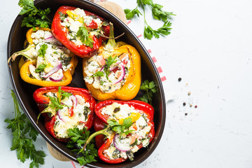 Stuffed paprika peppers with cheese and herbs. Top view on white.