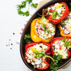 Stuffed paprika peppers with cheese and herbs. Top view on white.