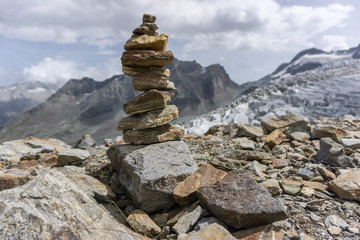 A beautiful cairn with mountains and a glacier in the background in the alps of switzerland. 
