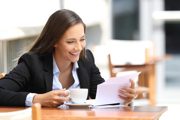 Businesswoman reading a letter in a coffee shop