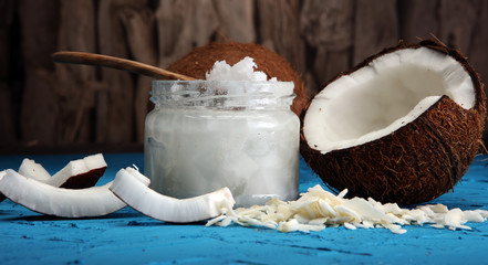 coconut oil and fresh coconuts on blue background