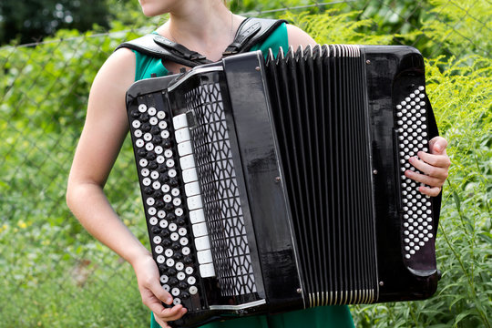 Girl musician plays the Russian bayan (button accordion).