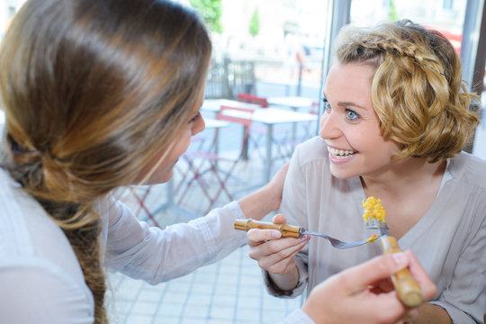 two women eating out in fast food restaurant talking