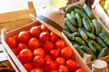 Tomatoes, cucumbers and green onions are in a wooden box.