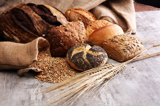 Different kinds of bread and bread rolls on board. Kitchen or bakery poster design.