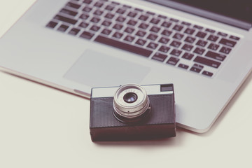 beautiful black camera and cool laptop on the wonderful pink background