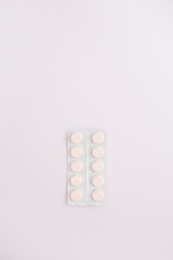Flat lay medicine pills on pink background. Top view medical texture.
