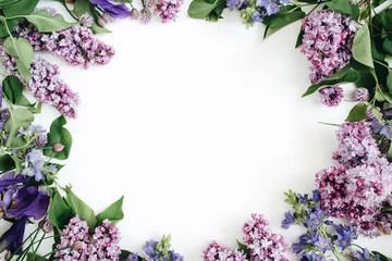 Foto auf Leinwand Rahmen aus lila Blumen, Zweigen, Blättern und Blütenblättern mit Platz für Text auf weißem Hintergrund. Flache Lage, Ansicht von oben © Floral Deco