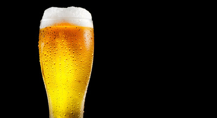 Beer. Glass of cold beer with water drops. Craft beer isolated on black background